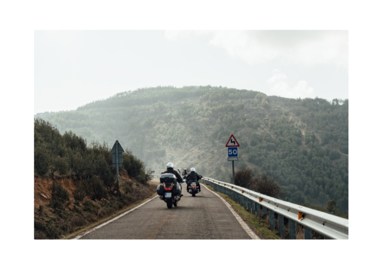 A motorcycle in motion on a curved road, demonstrating Newton's First Law where an object in motion stays in motion unless acted upon by an external force.