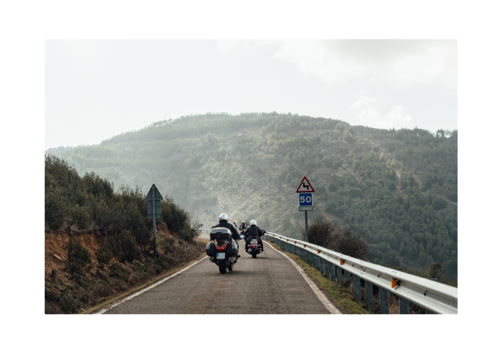 A motorcycle in motion on a curved road, demonstrating Newton's First Law where an object in motion stays in motion unless acted upon by an external force.