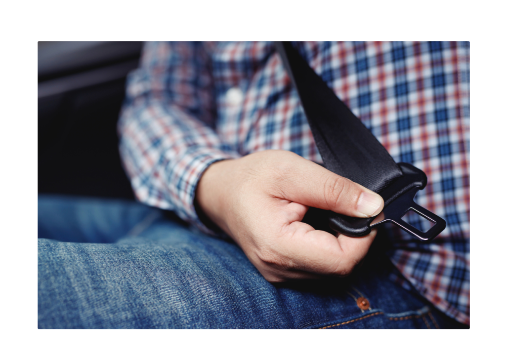 A person fastening a seatbelt in a car, demonstrating Newton's First Law where an object in motion will continue in motion unless acted upon by an external force.