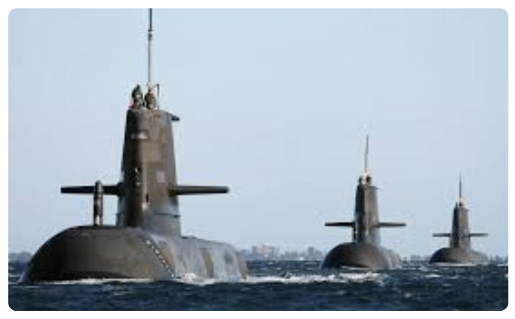 Three nuclear-powered submarines moving through the ocean surface.