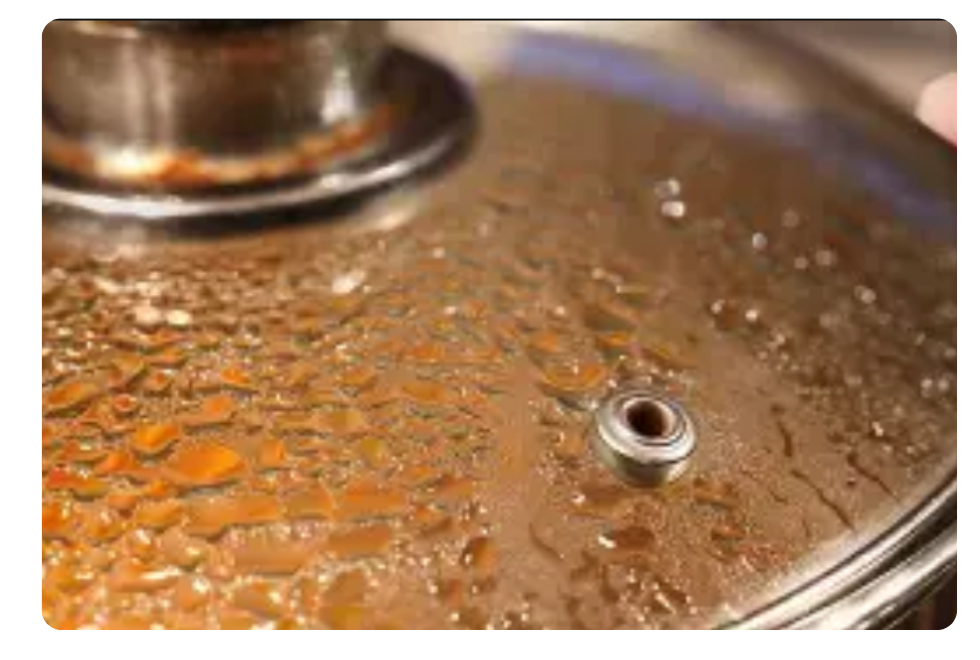 Water droplets forming on the inside of a pan lid due to condensation
